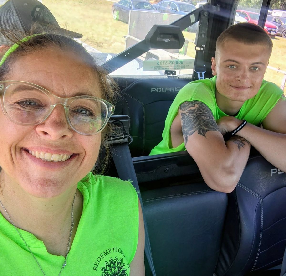 Two Redemptions Recovery volunteers in matching shirts sitting in a work vehicle.